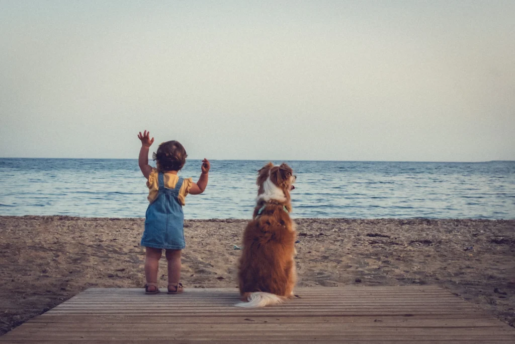 Una niña y un perro en la playa en una sesión de fotografia de perros en Murcia.